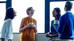 Four employees having a casual chat in office